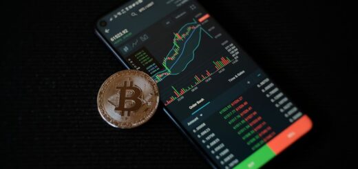 a bitcoin sitting on top of a smart phone