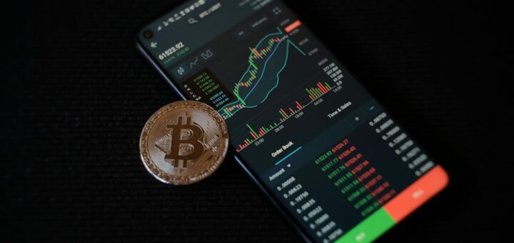 a bitcoin sitting on top of a smart phone