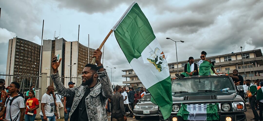 a group of people walking down a street holding a flag