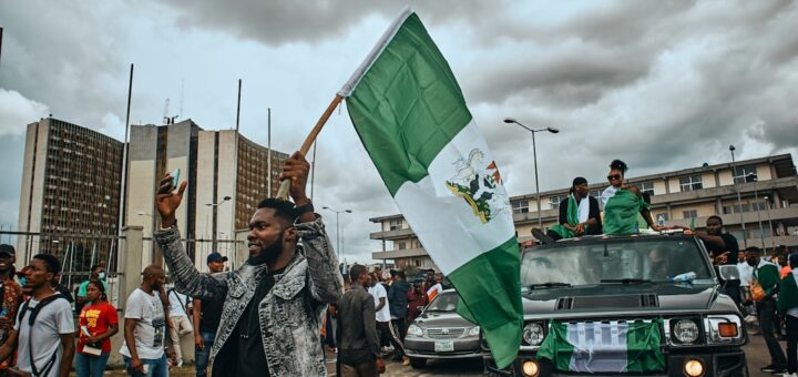 a group of people walking down a street holding a flag