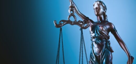 Statue of justice holding scales against blue background