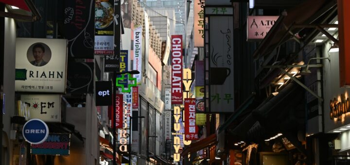A busy street lined with illuminated signs at night.