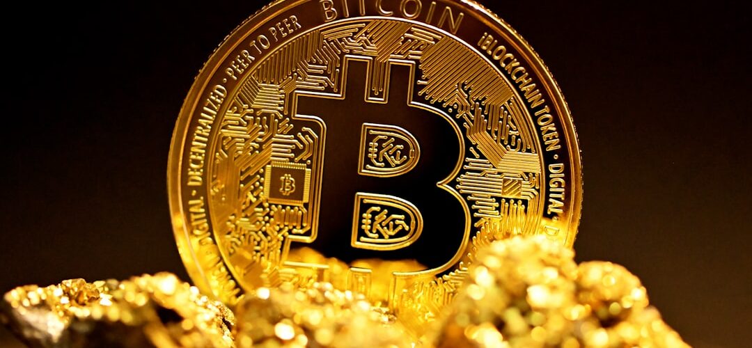 a bitcoin sitting on top of a pile of gold nuggets