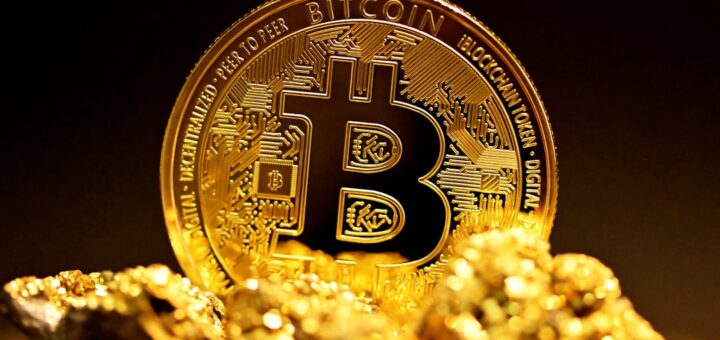 a bitcoin sitting on top of a pile of gold nuggets