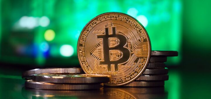 a bit coin sitting on top of a stack of coins
